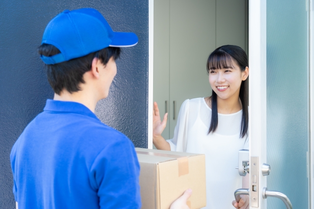 宅配クリーニングを受け取る女性の写真