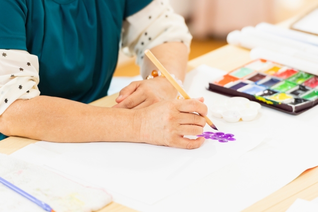 絵の具で絵を書いている女性の画像