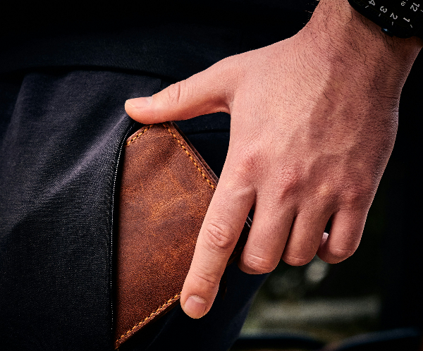 財布をポケットから取り出す男性の写真