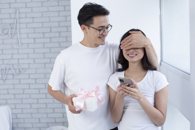 女性を目隠ししている男性の写真