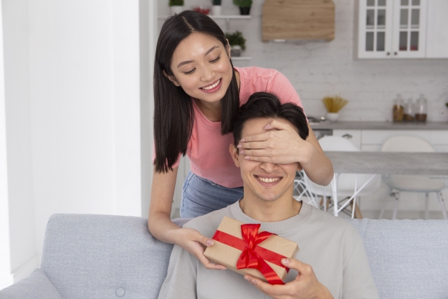 男性を目隠ししている女性の写真