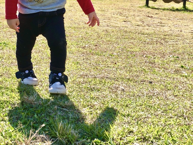 子供靴を履いて歩いている子供の写真